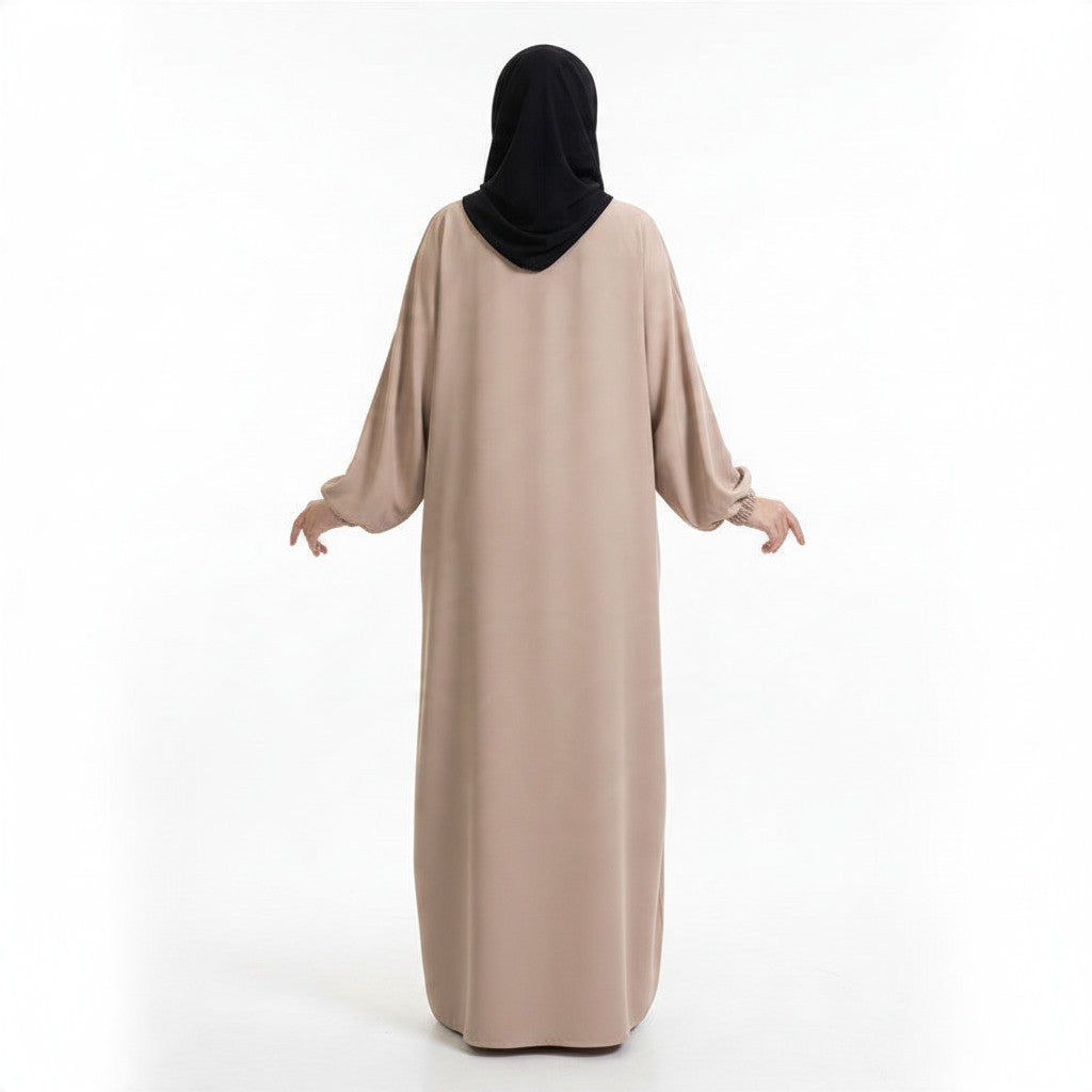 BelleNoor beige maxi abaya with long balloon sleeves and elasticated cuffs, shown from the back on a model in hijab.