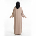 BelleNoor beige maxi abaya with long balloon sleeves and elasticated cuffs, shown from the back on a model in hijab.