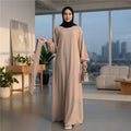 BelleNoor beige maxi abaya with balloon sleeves and elastic cuffs, worn by a woman with a black hijab in a bright room