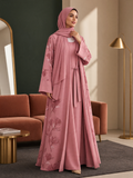BelleNoor dusty pink floral print open abaya set with matching inner dress and hijab in a modern living room setting
