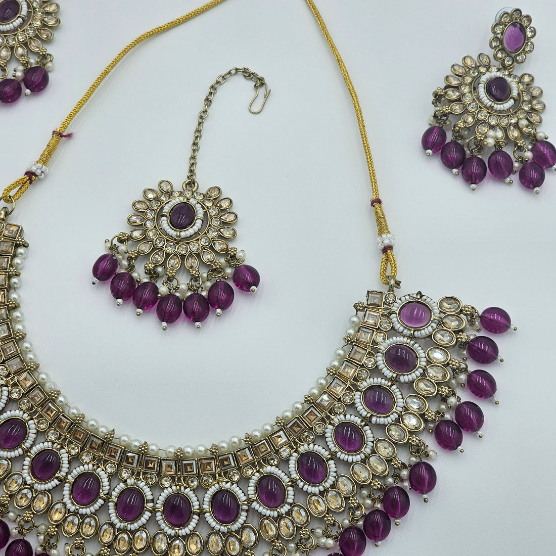 BelleNoor royal purple Kundan jewellery set featuring a statement necklace, chandelier earrings, and maang tikka.