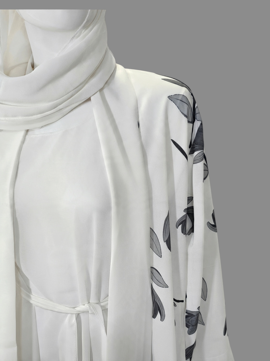 BelleNoor white abaya with black and grey floral branch print, open front, waist tie, and matching hijab on mannequin